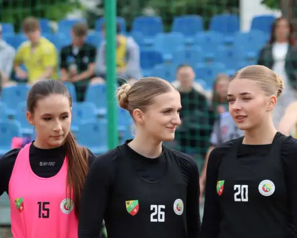 Trzy zawodniczki KPR Kobierzyce przed meczem. Dziewczyny w sportowych strojach, z numerami na koszulkach, gotowe do gry.