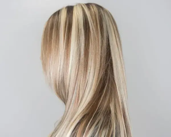 Piękne, długie włosy z kontrastującymi pasemkami blond, które dodają im głębi i blasku.