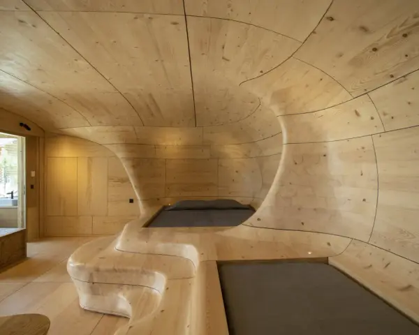 Interior de una casa cueva con paredes y techo de madera curvada, creando un espacio orgánico y acogedor.