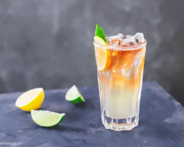 Orzeźwiający drink Long Island Iced Tea z plasterkami cytryny i limonki, idealny na upalne dni.