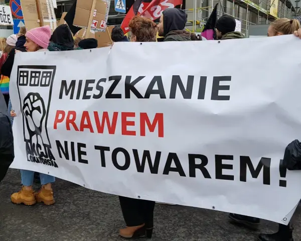 Protestujący niosą transparent "Mieszkanie prawem nie towarem!", domagając się ustaw chroniących lokatorów.