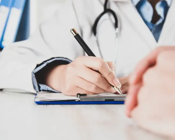 Lekarz pisze receptę, zastanawiając się, czy zwolnienie od psychiatry zostaje w papierach.