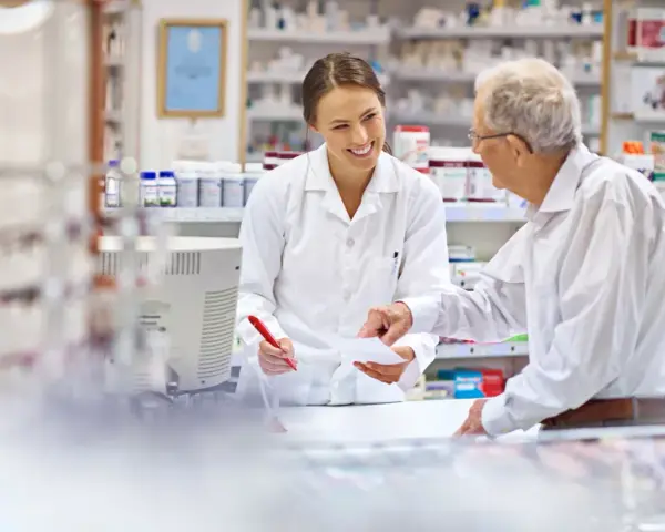 Farmaceutka pomaga seniorowi zrealizować receptę na darmowe leki.