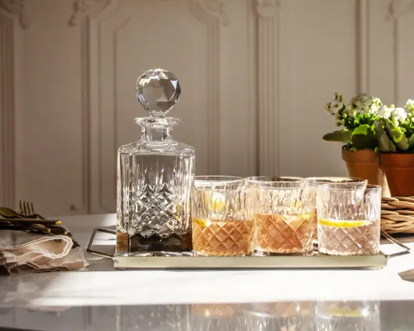 Elegancka karafka i szklanki z drinkami, idealne do degustacji whisky. Z czym pić whisky? Z cytryną i lodem, w dobrym towarzystwie.