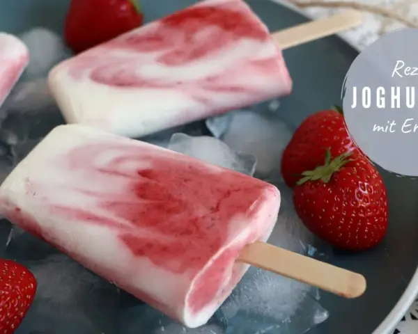 Leckeres Joghurt-Erdbeer-Eis am Stiel, perfekt zum kinder eis selber machen. Frische Erdbeeren und Eiswürfel garnieren das süße Rezept.
