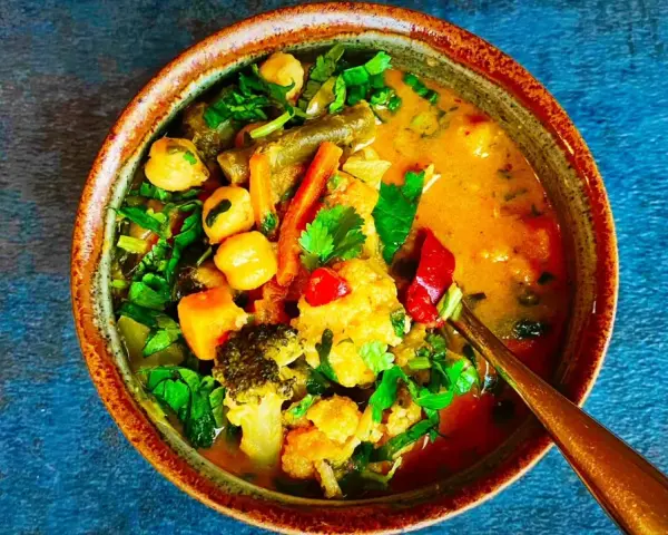 Miseczka tajskiego curry z warzywami, ciecierzycą i mlekiem kokosowym.