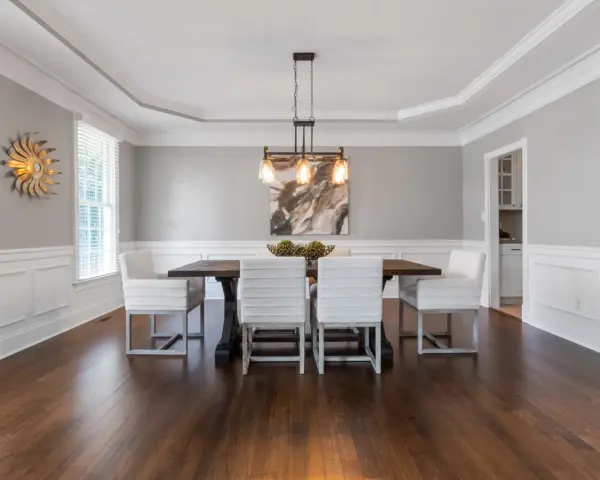 Comedor elegante con paredes y techo pintados del mismo color gris claro, creando un ambiente sereno.