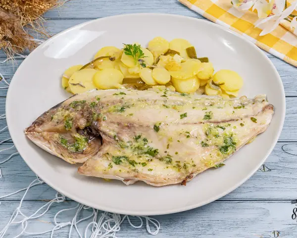 Dorada al horno con patatas panaderas, un plato principal delicioso y saludable.