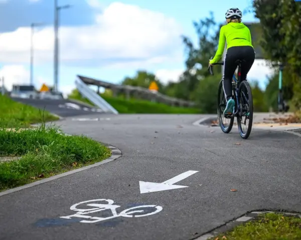 Kobieta na rowerze przemierza malownicze trasy rowerowe Kujawsko-Pomorskie.