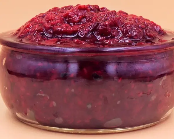 Pyszny mus malinowy z mrożonych malin w szklanym naczyniu.