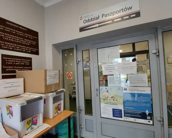 Oddział Paszportów w Zielonej Górze. W holu stoją pudła i pojemniki, a na drzwiach wiszą ogłoszenia.
