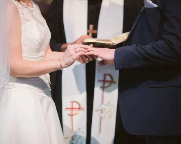 Para młoda wymienia obrączki podczas ceremonii ślubnej w kościele.