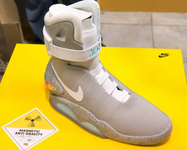 Nike Mag, najdroższe buty na świecie, z technologią "Magnetic Anti Gravity", prezentowane na żółtym tle.