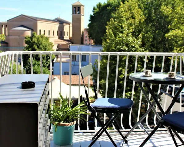 Balkon z widokiem na rzymskie dachy i kościół. Idealne miejsce, by zastanowić się, gdzie nocować w Rzymie.