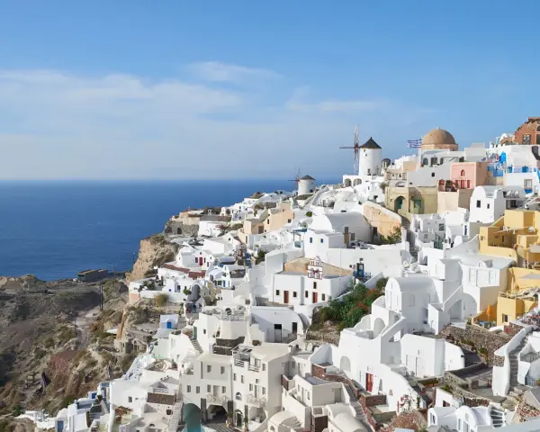 Widok na białe domy i wiatraki na klifie nad morzem, Santorini.