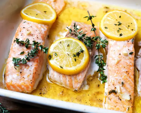 Saftiger Lachs im Ofen, garniert mit Zitronenscheiben und frischem Thymian, bereit zum Genießen.