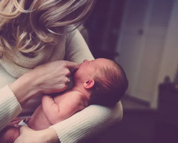 Delikatne dotknięcie palcem ust noworodka, gdy mama próbuje poradzić sobie z kryzysem laktacyjnym.