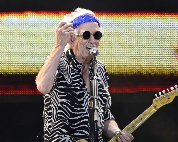 Keith Richards heute, mit blauem Bandana und Sonnenbrille, spielt Gitarre auf der Bühne.