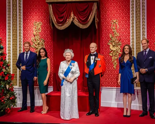 Figury królewskie w muzeum figur woskowych Londyn: Elżbieta II, książę Filip, książę Harry, Meghan Markle, książę William i Kate Middleton.