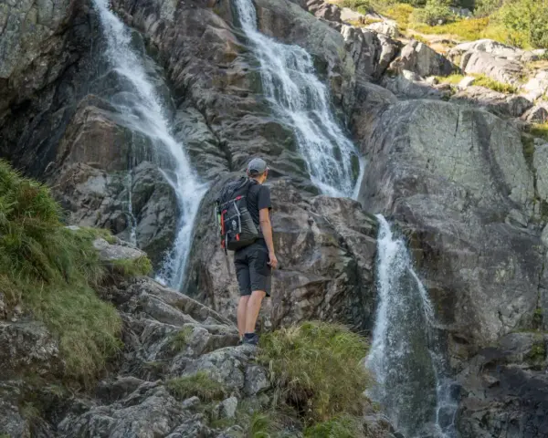 Turysta podziwia wodospad w Tatrach. Wspaniałe widoki, gdzie w Tatry warto się wybrać.