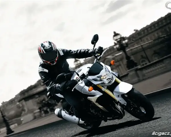 Motocyklista na białym Suzuki GSR 750 pokonuje zakręt. Nawet z potencjalnymi wadami, jazda nim to czysta przyjemność.