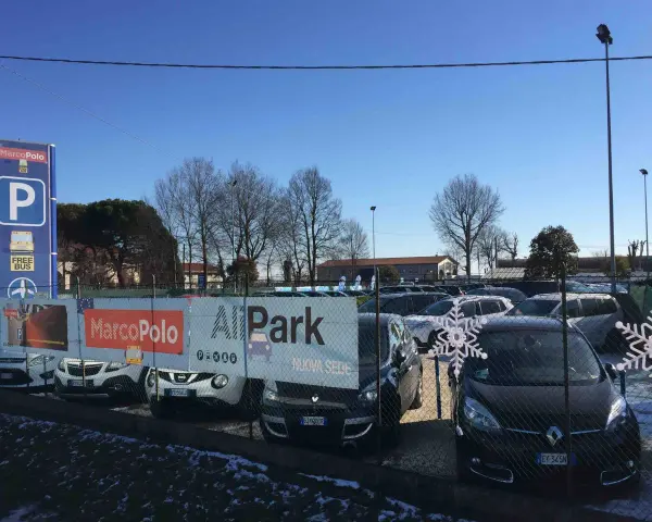 Parcheggio all'aeroporto di Venezia Marco Polo con cartelli informativi e auto in sosta.