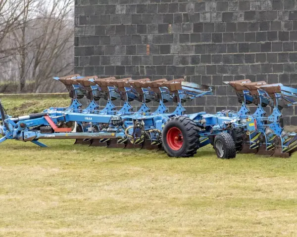 Potężny, niebieski pług 10 skibowy Lemken, gotowy do pracy na polu.