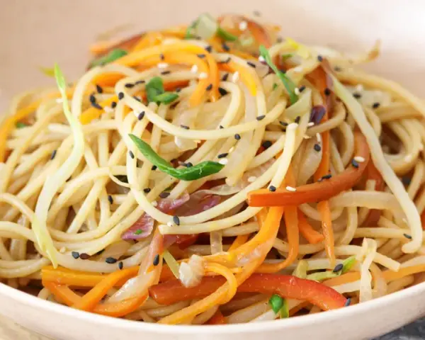 Chow mein en un tazón con verduras y semillas de sésamo.