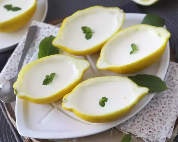 Fyra citroner fyllda med krämig dessert, garnerade med mynta. Perfekt för enklaste julbaket.