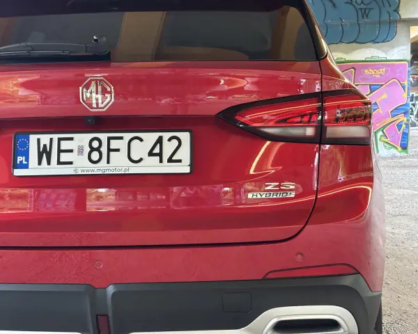 Czerwony tył samochodu MG ZS Hybrid z tablicą rejestracyjną WE 8FC42.
