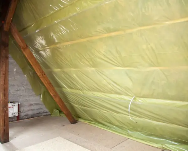 Na poddaszu rozłożona folia paroizolacyjna na drewnianych belkach, chroniąca przed wilgocią.