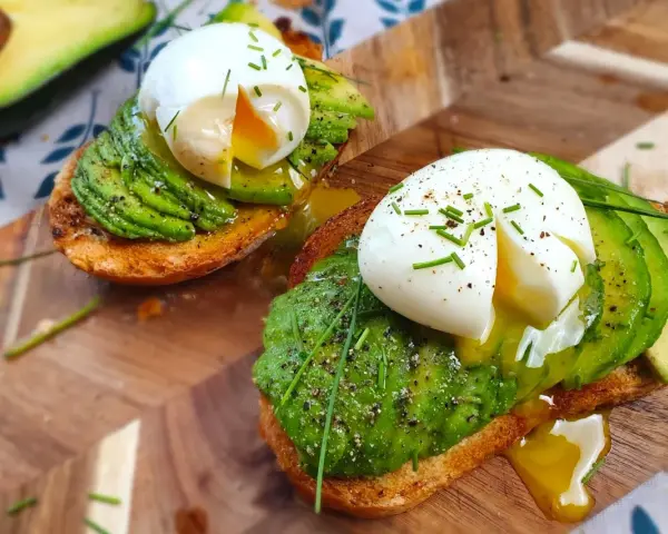 Toast con uova in camicia e avocado, un piatto delizioso e salutare, pronto per essere gustato.