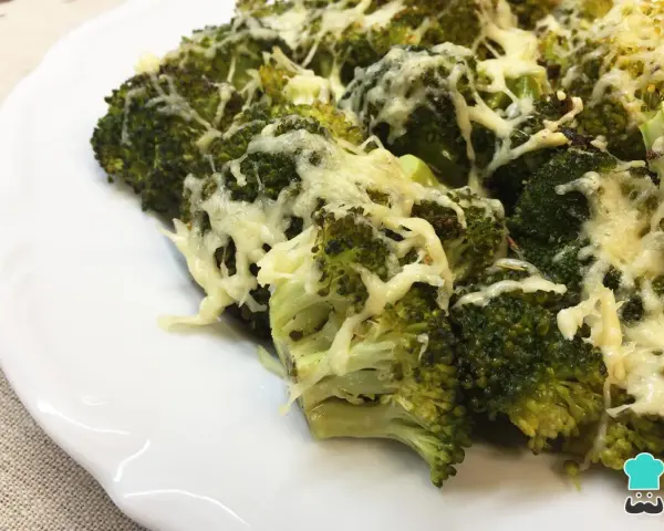 Brocoli al horno gratinado con queso, servido en un plato blanco.