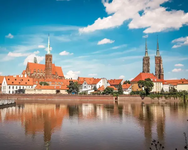 Wrocławskie Ostrów Tumski z katedrą i kościołami, odbijające się w wodzie. W tle widać budynki, które mogłyby pomieścić muzeum sztuki mieszczańskiej.
