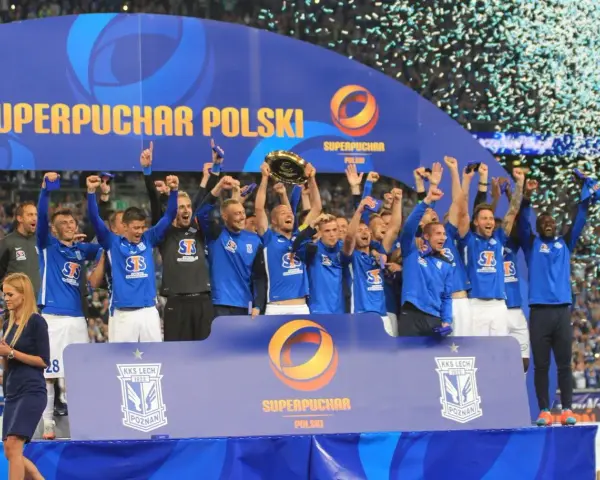 Drużyna w niebieskich strojach świętuje zdobycie Superpucharu Polski, unosząc trofeum i ciesząc się z wygranej wśród konfetti.