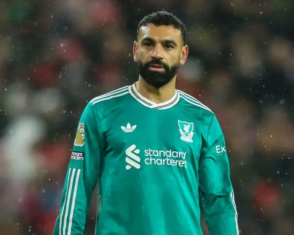 Mohamed Salah w zielonej koszulce Liverpoolu, symbol jego obecności w klubie, która jest kluczowa dla transferów Liverpool.