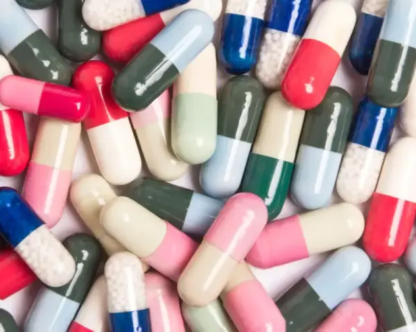 Kolorowe kapsułki leków, które mogą wywołać pieczenie pochwy po antybiotyku.