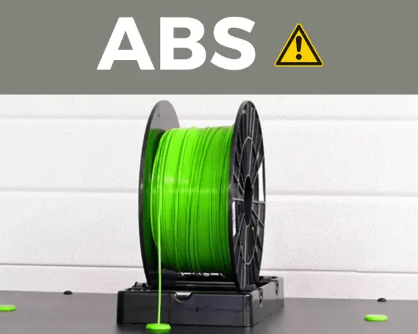A spool of bright green ABS plastic filament, commonly used for 3D printing durable parts.