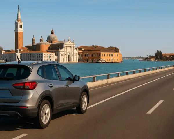 Un'auto grigia percorre il ponte verso Venezia, con la Basilica di San Giorgio Maggiore e il campanile che si stagliano sullo sfondo.