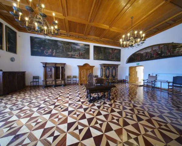 Wnętrze muzeum Gdańska - Ratusz Głównego Miasta. Bogato zdobiona sala z zabytkowymi meblami, obrazami i misterną parkietową posadzką.