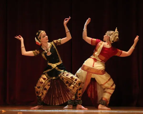 Anna Łopatowska i partnerka w tradycyjnych strojach tańczą taniec klasyczny Bharatanatyam.