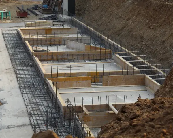 Szkielet zbrojeniowy i szalunki czekają na beton. Widać, ile bloczków na fundament potrzeba do budowy.