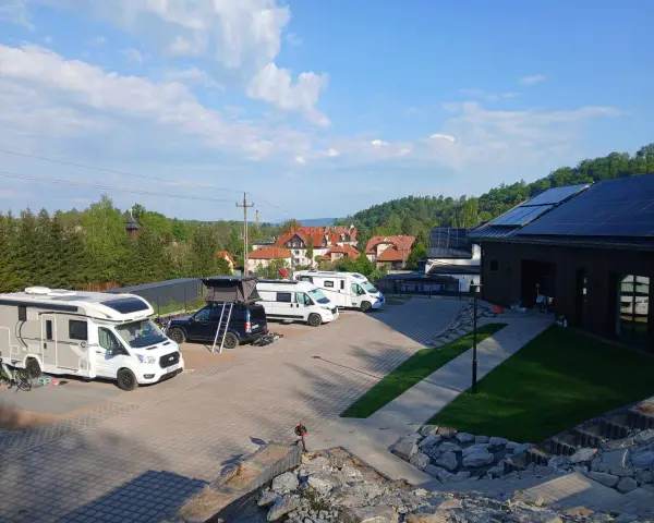 Kampery i samochody kempingowe zaparkowane na placu, gotowe na przygodę w Kudowie-Zdroju.