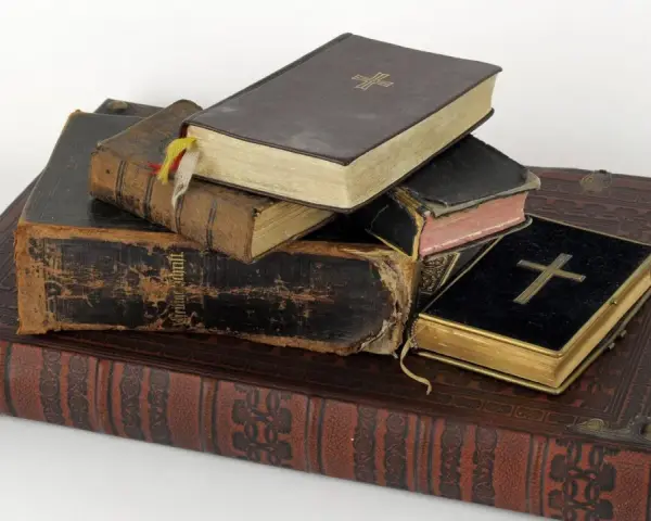 Stapel alter Bücher, einige mit Kreuzen auf dem Einband.