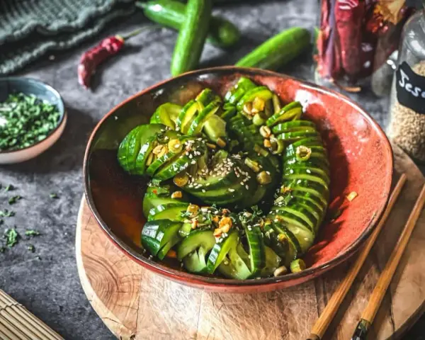 Ein erfrischender asiatischer Gurkensalat, garniert mit Sesam und Kräutern, bereit zum Genießen.
