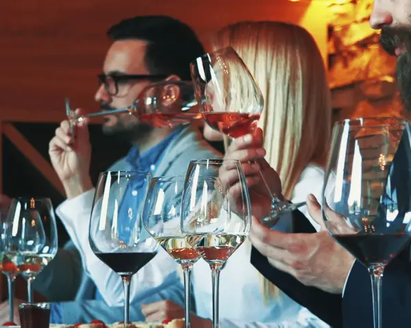 Gente disfrutando de una cata de vinos en España, con copas de vino tinto, blanco y rosado.