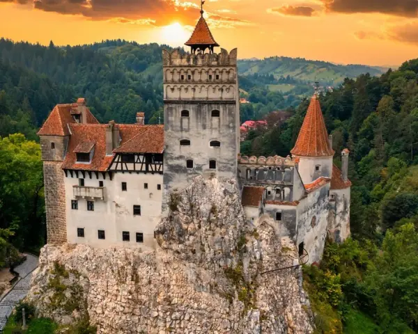 Majestatyczny zamek w Transylwanii, górujący nad lasami o zachodzie słońca.