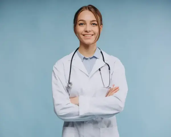 Uśmiechnięta lekarka w białym kitlu ze stetoskopem, zastanawia się, ile zarabia psychiatra.