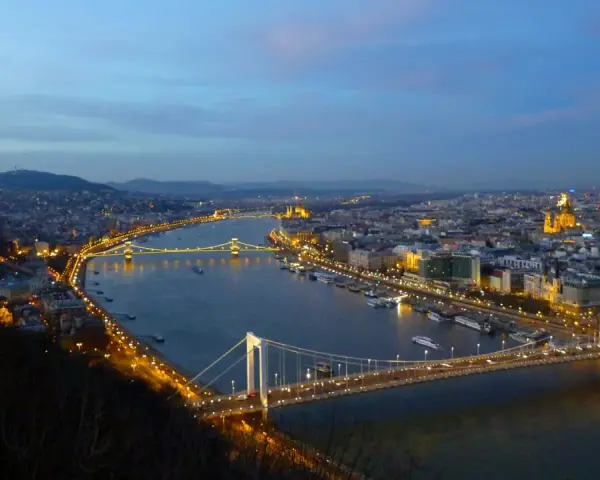 Vista nocturna de Budapest con el río Danubio y sus puentes iluminados, creando un paisaje urbano mágico.
