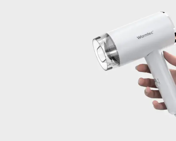 Biała suszarka Warmtec trzymana w dłoni.